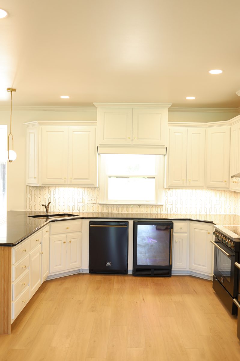 Full custom kitchen layout with black granite countertops and geometric tile backsplash