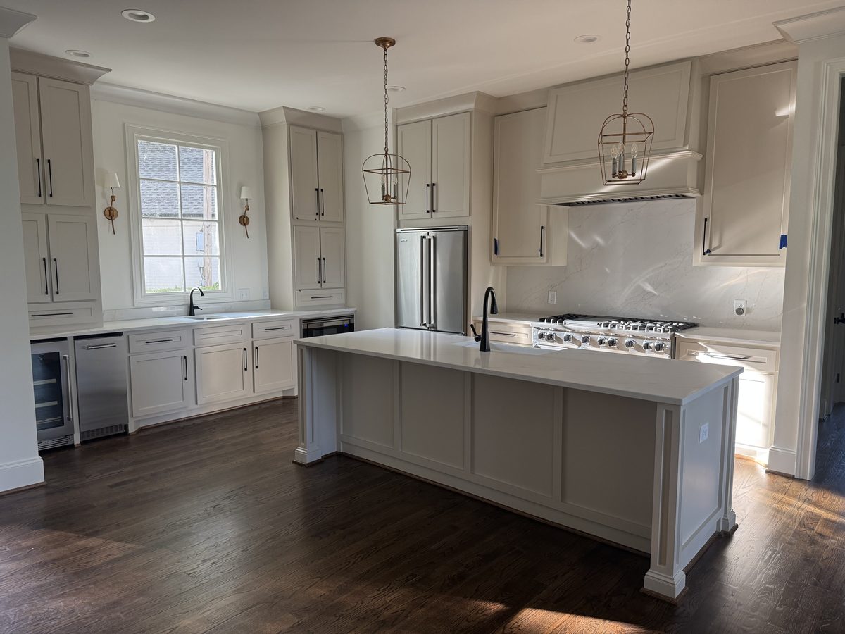 Full custom white kitchen with wood island and pendant lighting