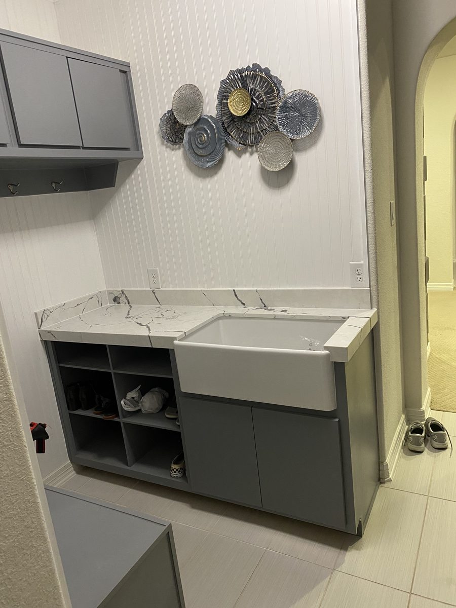 Custom mudroom cabinetry with farmhouse sink and marble counter