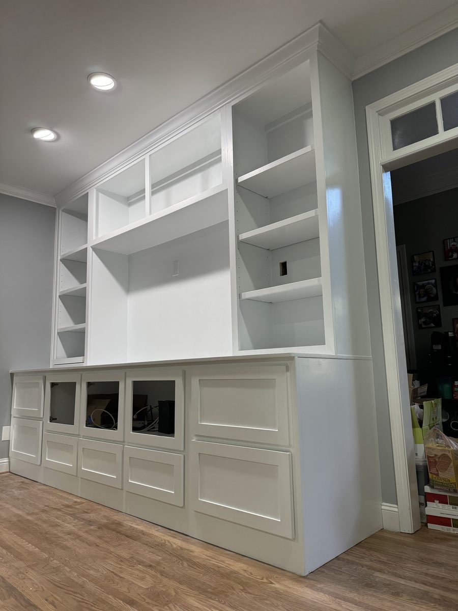 Floor-to-ceiling white built-in shelving and cabinetry