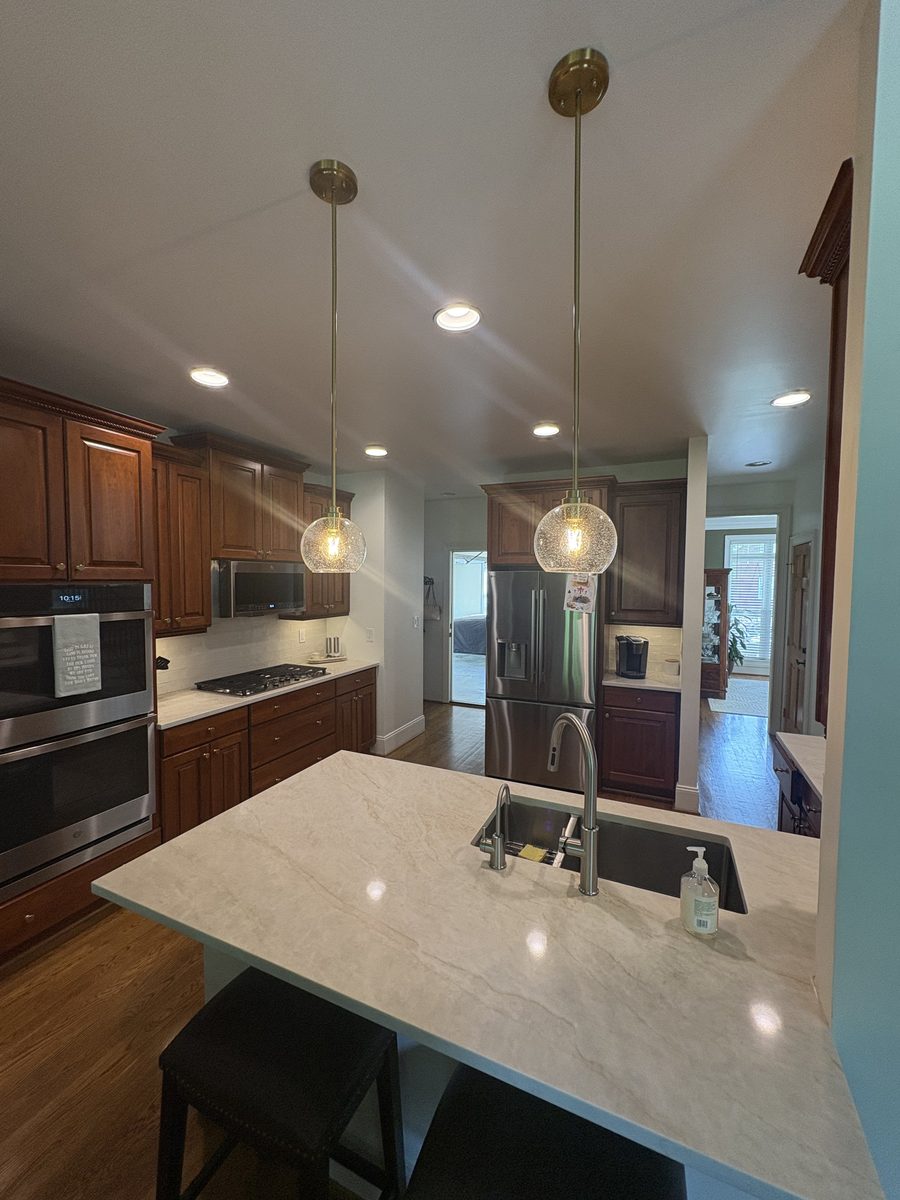 Traditional dark wood kitchen with brass pendant lighting