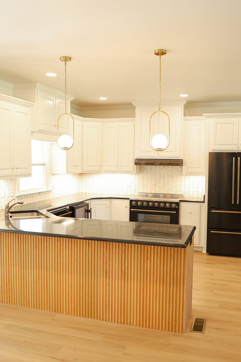 Fluted white oak island with waterfall granite countertop
