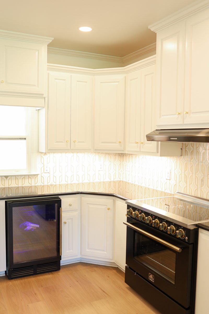 Corner cabinetry and range detail, hand-finished white panels