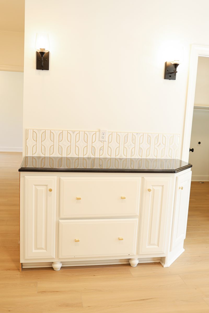 Matching built-in cabinetry with black granite top and sconce lighting