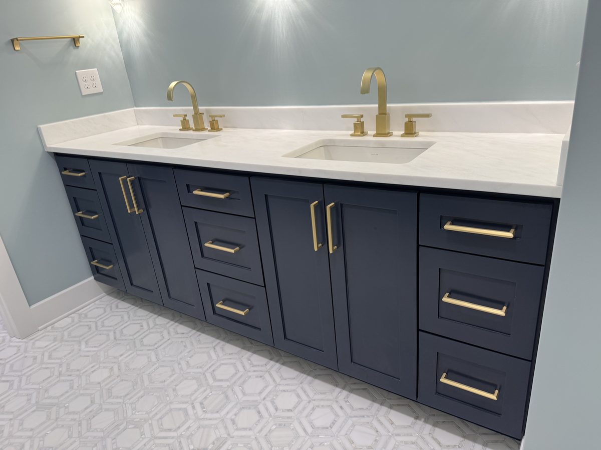 Custom navy double-sink bathroom vanity with brass fixtures